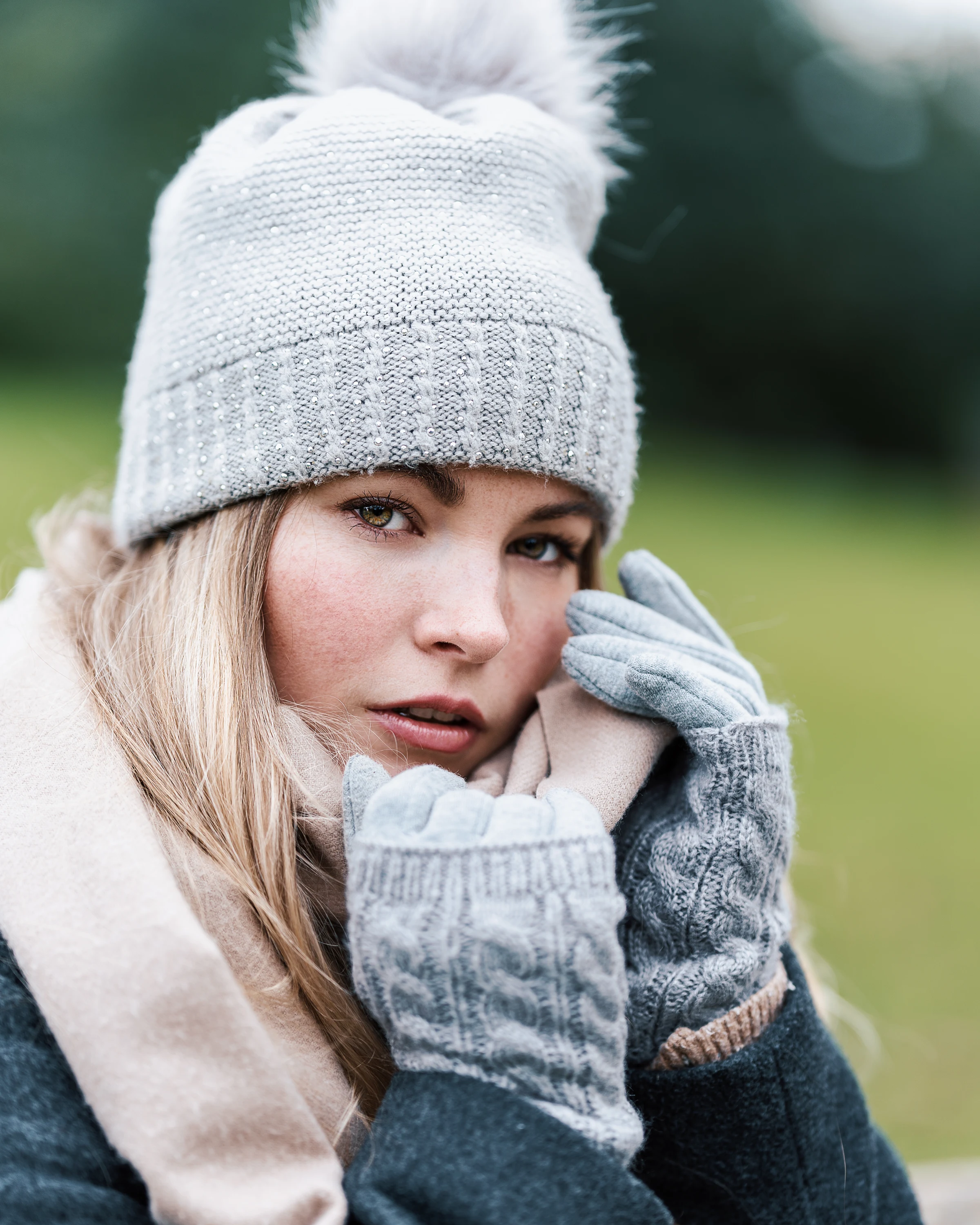 Winter portrait of a woman wearing a grey beanie and gloves