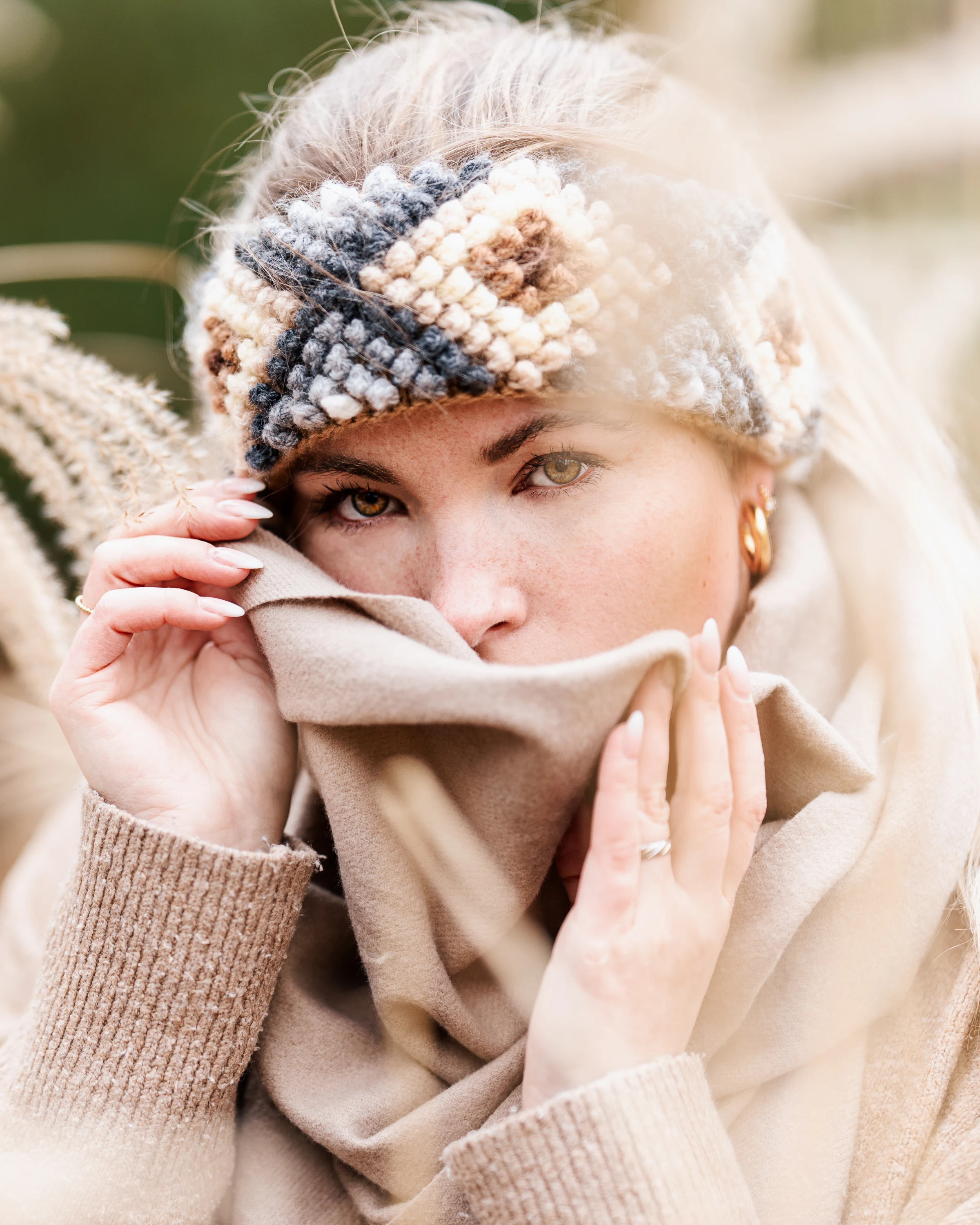 Winter portrait of a woman wearing a warm headband and scarf