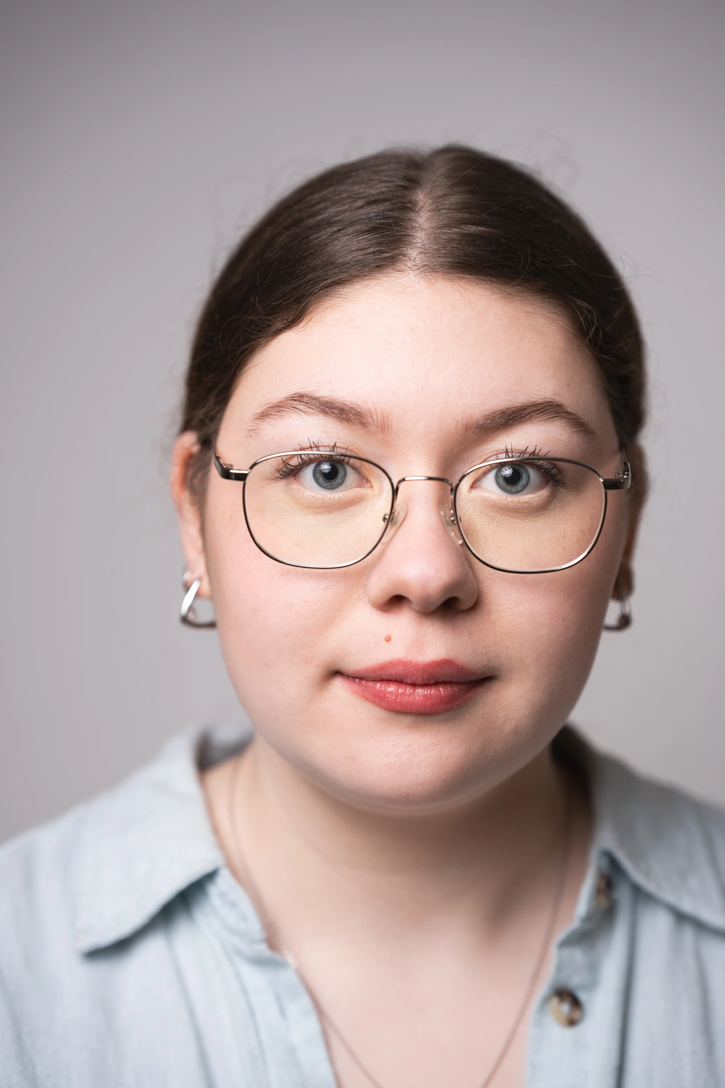 Professional studio headshot with a clean neutral expression